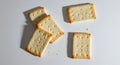 Crispy rectangular crackers arranged on a white surface with crumbs scattered around Royalty Free Stock Photo