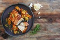 Crispy roast pork with vegetables, rosemary and garlic on a rust Royalty Free Stock Photo