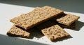 Crispy rye crackers with seeds, illuminated by sunlight on a white surface Royalty Free Stock Photo