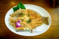 Crispy Sea Bass on White Dish on Wood Table Royalty Free Stock Photo