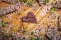 Crispy seed homemade bread decorated with microgreen sprouts with a heart shaped figure laid out from flax seeds on a wooden table Royalty Free Stock Photo