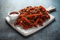 Crispy shredded beef with carrots and sweet chilli sauce on white wooden board. Chinese takeaway food Royalty Free Stock Photo