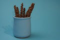 Crispy sticks with hazelnut sprinkles in chocolate on a blue background. Royalty Free Stock Photo