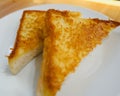 Crispy and tasty yellow bread french toast on white ceramic plate. Delicous fast meal for family. Yummy but unhealthy. Selective f