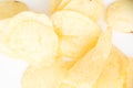 Crispy thinly sliced potato chips closeup, on white