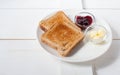 Crispy toast with butter and jam. Served on a white dish