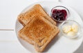 Crispy toast with butter and jam. Served on a white dish