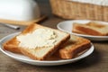 Crispy toasted bread with butter on wooden table