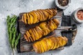 Crispy Tornado or twist potatoes chips on wooden board. Gray background. Top view