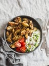 Crispy za`atar fries with garlic scallion yogurt sauce in a frying pan on a light background. Delicious appetizers