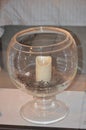 Cristal candle holder with white candle alight and pine cones on a indoors table