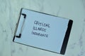 Critical Illness Insurance write on a paperwork isolated on Wooden Table Royalty Free Stock Photo