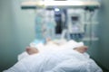 Critically ill patient in ICU ward, blurred medical background Royalty Free Stock Photo