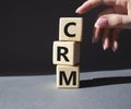 CRM - Customer relationship management symbol. Concept word CRM on wooden cubes. Businessman hand. Beautiful grey background. Royalty Free Stock Photo