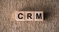 CRM Customer Relationship Marketing written on a wooden cube in table. Business concept