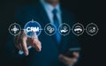CRM Software for Customer Management. Businessman touches a virtual CRM icon, showcasing digital tools for customer relationship