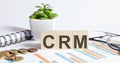 CRM word on the wood blocks concept with chart, coins, notebook and glasses Royalty Free Stock Photo