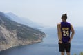 Croatia, August 3 2017, Young man standing in shorts, t-shirt and sunglasses looking out the ocean Royalty Free Stock Photo