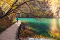 Croatia nature park Plitvice Lakes in autumn - boy walks on bridge over the lake Royalty Free Stock Photo