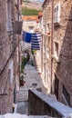 Croatia.Summer sunny day.Residential street of old Dubrovnik.Potted flowers are near the houses. Royalty Free Stock Photo