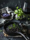 Croatian crni rizot, a traditional black risotto made with squid ink, served in a skillet. This distinctive ethnic dish