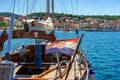 Croatian flag on wooden beautiful sailer boat in mali losinj island port croatia with colorful buildings and blue sea