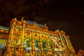 Croatian national theatre building during festival of light, coloured in colorful light animations agains the clouds sky
