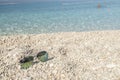 Croatian pebble beach with sunglasses Royalty Free Stock Photo