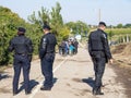 Croatian policemen looking at migrants crossing the Serbia Croatia border in Berkasovo Bapska, on the Balkans Route