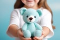 Crochet blue bear in girl hands. Cute handmade toy. Japanese amigurumi