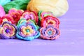 Crochet Flowers Embellished With Buttons And Beads. Beautiful Crochet Flowers, Colored Cotton Yarn On Purple Wooden Table