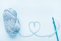 Crochet heart  hook and ball of yarn on a blue background with copy space Royalty Free Stock Photo