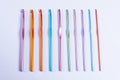 Crochet hooks of different sizes and colors arranged in one row, rainbow palette