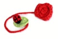 Crochet ladybird on the leaf near crocheted rose Royalty Free Stock Photo