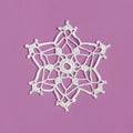 Crochet snowflake isolated on pink. Handmade decorative knitted doily snowflake. Winter or Christmas decoration. Square
