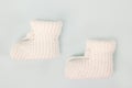 Crochet white baby booties, on a gray background, Royalty Free Stock Photo