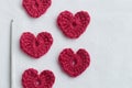 Crocheted amigurumi pink heart with crochet hook and skein of yarn on a white background. Valentine\'s day banner