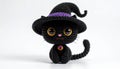 Crocheted Black Cat in Witch Hat with Purple Band on White Background Royalty Free Stock Photo