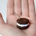 Crocheted brown cookies with a layer of white cream. Keychain on