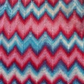 Crocheted dress made of red, pink, blue threads with a zigzag missoni pattern Royalty Free Stock Photo