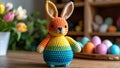 Crocheted Easter bunny with colorful rainbow design and eggs on wooden table Royalty Free Stock Photo