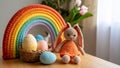 Crocheted Easter bunny, eggs, and rainbow on a wooden table, holiday decor Royalty Free Stock Photo
