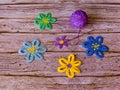 Crocheted flowers and ball of violet yarn on wooden background Royalty Free Stock Photo