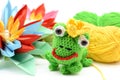 Crocheted frog king with crown and paper water lily. Royalty Free Stock Photo