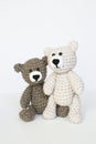 Crocheted gray and brown bears on a white background. Crocheted toy.