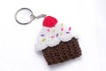 Crocheted keychain in the shape of a vanilla and raspberry cupcake