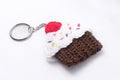 Crocheted keychain in the shape of a vanilla and raspberry cupcake