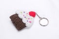 Crocheted keychain in the shape of a vanilla and raspberry cupcake