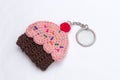 Crocheted keychain in the shape of a vanilla and raspberry cupcake