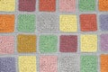crocheted lace tablecloth of multicolored squares ornament on a gray background, top view, place for text, natural wool